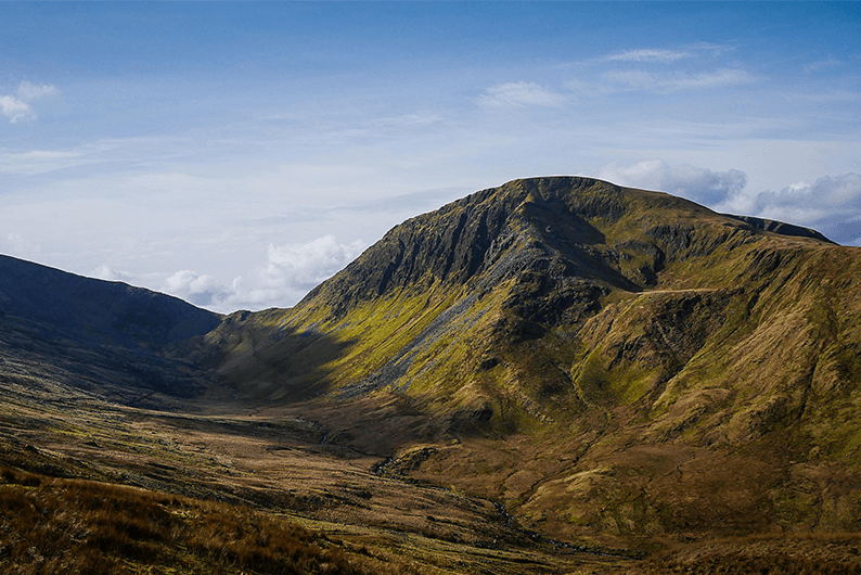Ruig berglandschap in Snowdonia, Noord-Wales, met zonlicht over de hellingen.