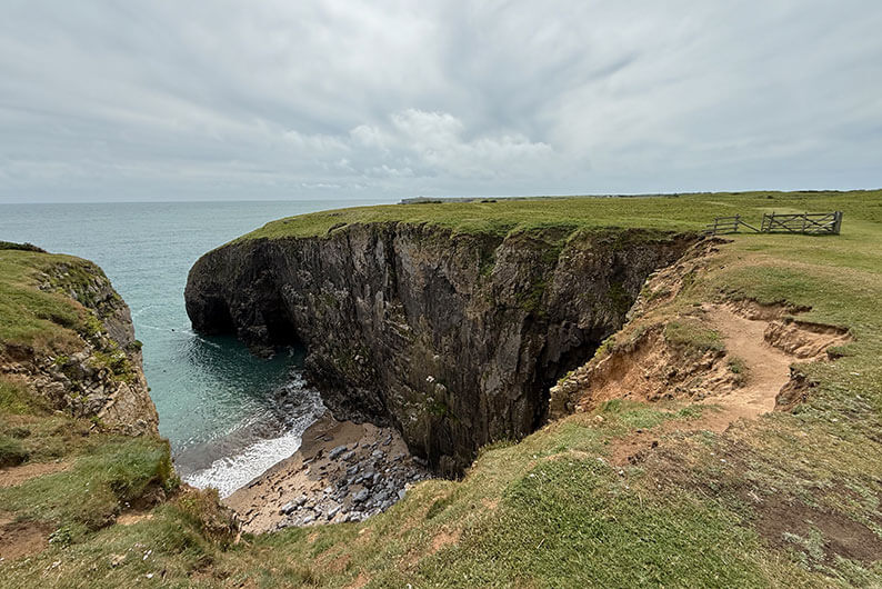 Kleine baai met hoge kliffen langs het Pembrokeshire Coast Path bij Stackpole