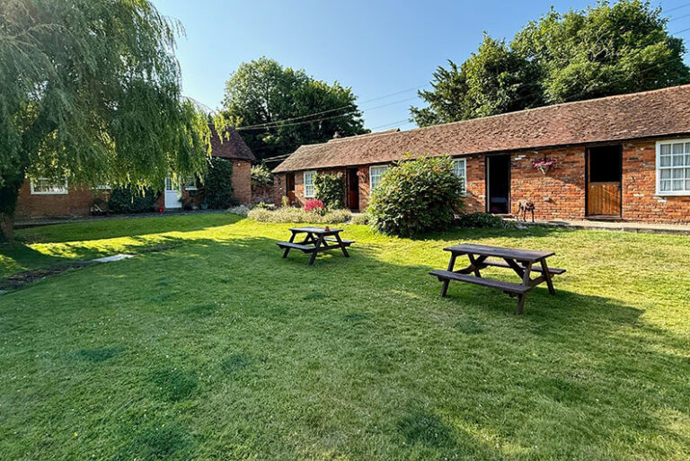 Tuin met picknicktafels bij Beachborough Park, hondvriendelijke overnachting onderweg naar Engeland