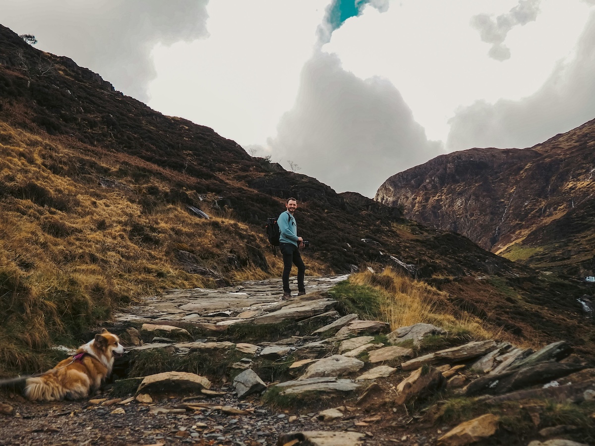 Wandelaar met hond op een bergpad in Snowdonia in Noord Wales